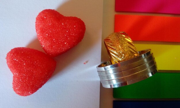 Directly above shot of wedding rings and heart shapes on table