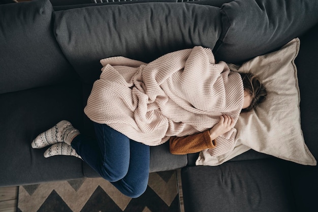 directly above shot of woman lying on sofa