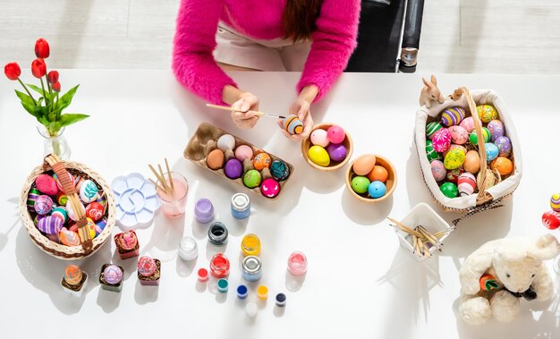 Foto direttamente sopra la foto di una donna che dipinge uova di pasqua