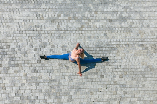 Photo directly above shot of woman stretching on street