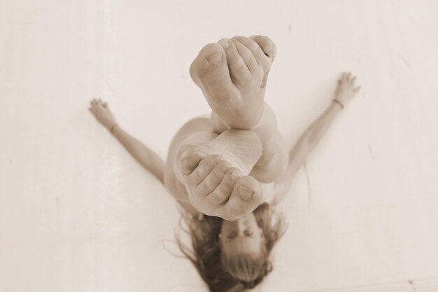 Photo directly above shot of woman with feet up lying on floor