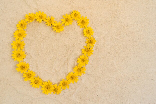 Photo directly above shot of yellow heart shape on sand surface