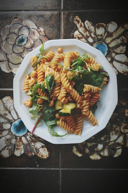 Foto vista direttamente sopra di pasta fresca servita in piatto su un pavimento piastrellato