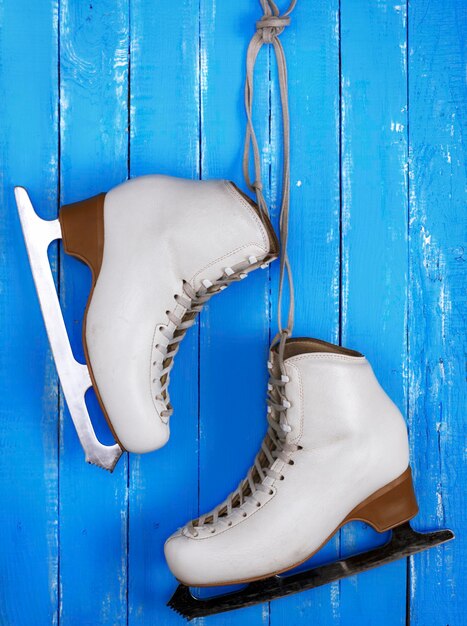 Photo directly above view of ice skates on blue wooden table