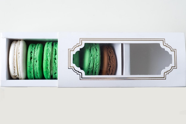 Photo directly above view of macaroons in box over white background