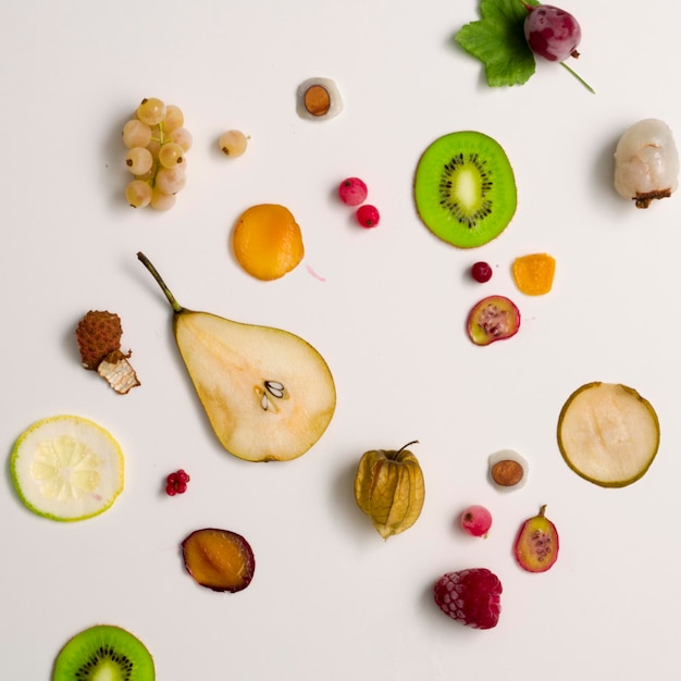 Photo directly above view of various fruits on white background