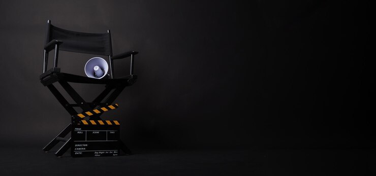Стул директора и доска Clapper и мегафон на черном фоне