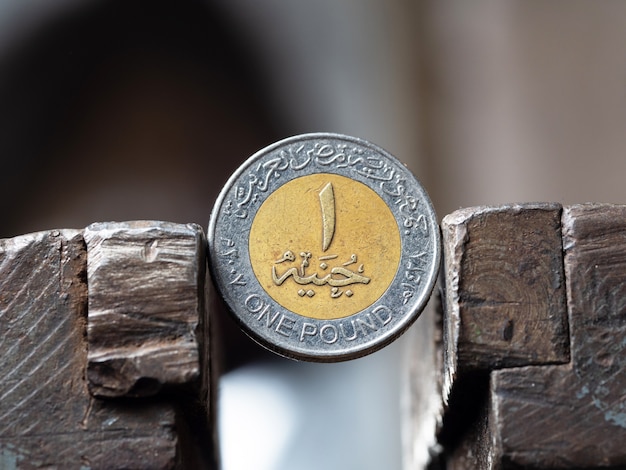 Dirham coin clamped in a metal vise