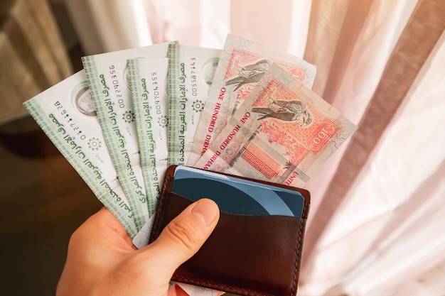 Dirham contante bankbiljetten in de hand met portemonnee Financiële opleiding en Aed wisselkoers