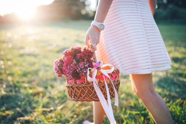 写真 ピンクのドレスに花のバスケットを持つ少女