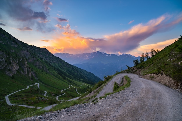 Dirt mountain road leading to high mountain pass in Italy