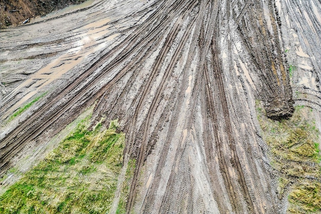 建設現場の雨上がりの未舗装道路 上空からの眺め ドローン撮影 重機で整備された進入路