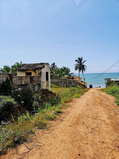 Photo dirt road amidst buildings against sky