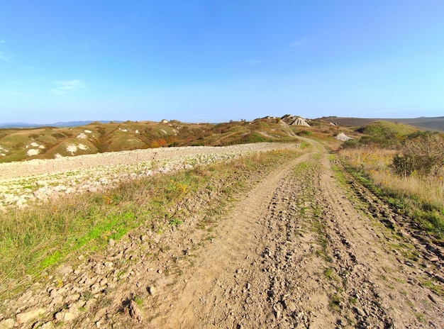 Foto strada di terra in mezzo al campo contro il cielo blu