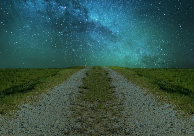 Photo dirt road amidst field against sky