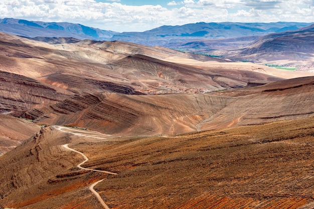 A dirt road descends into the deep deserted valley of Dades in the Atlas Mountains in Morocco