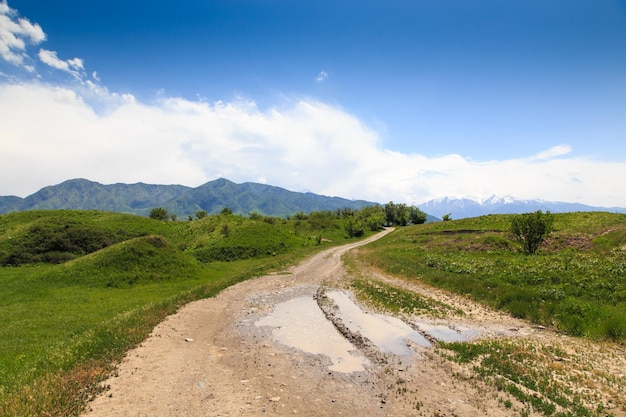 Una strada sterrata in montagna con un cielo blu alle spalle