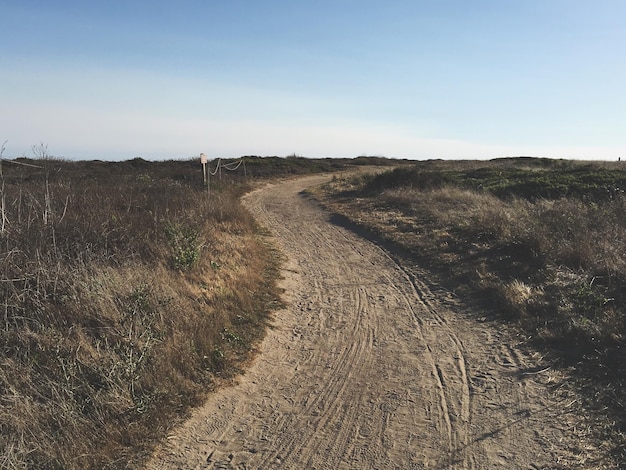 Photo dirt road passing through field