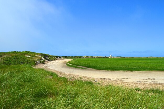 Photo dirt road passing through landscape against clear sky