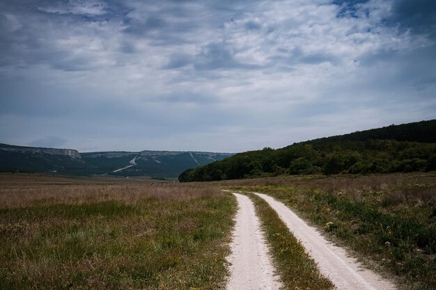 Dirt road among the spring field Before the storm