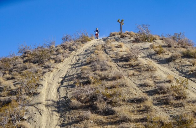 dirtbike rider coming down from large hill