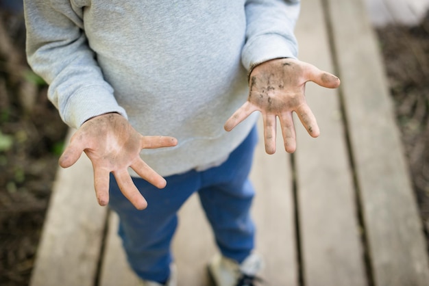 더러운 아기 손바닥이 닫혀 차일즈의 손이 땅과 모래 위생 개념으로 얼룩져 있다