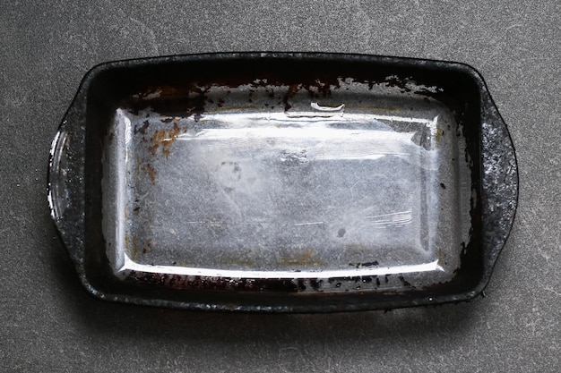 Dirty baking dish with a thick layer of carbon glassware for baking with soot carbon deposits old dr...