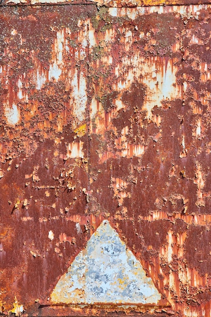 Dirty brown orange rusted panel with distinct silver triangle abstract background asset corroding