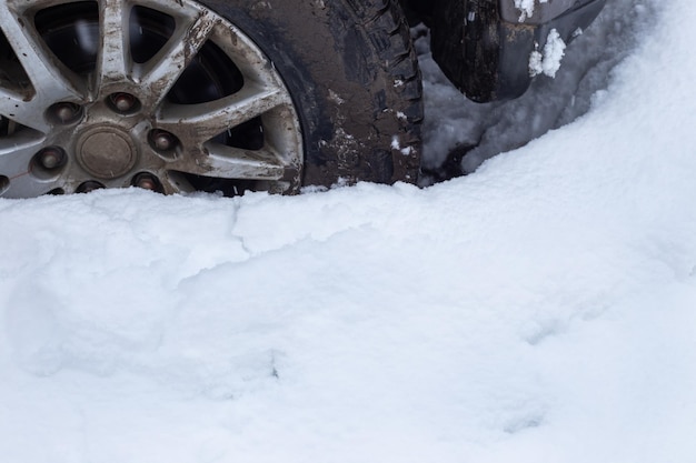 눈 덮인 도로에 끼인 더러운 자동차 바퀴 겨울에 눈이 흩날리다
