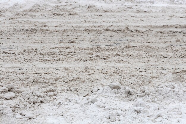 冬の汚い街。道路上の雪の山。高品質の写真