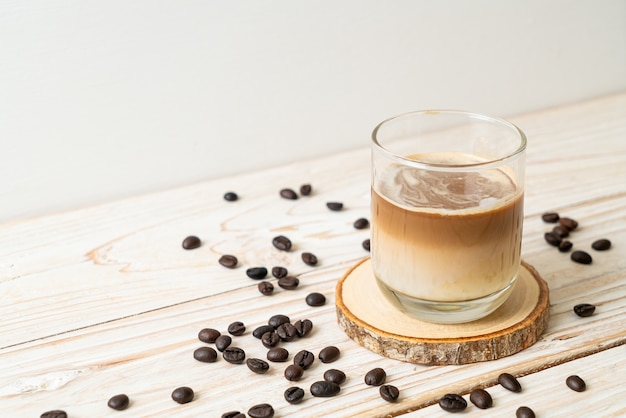 Грязный кофейный стакан, холодное молоко, залитое горячим кофе эспрессо