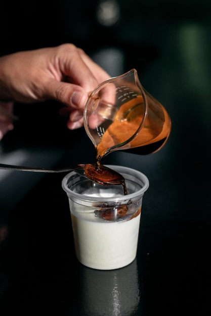 汚れたコーヒー - コーヒー ショップ カフェやレストランで冷たい新鮮な牛乳を混ぜたエスプレッソ ショットのグラス