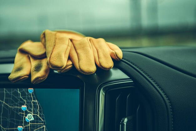 Photo dirty construction worker's gloves on a pickup truck dashboard commercial vehicle interior