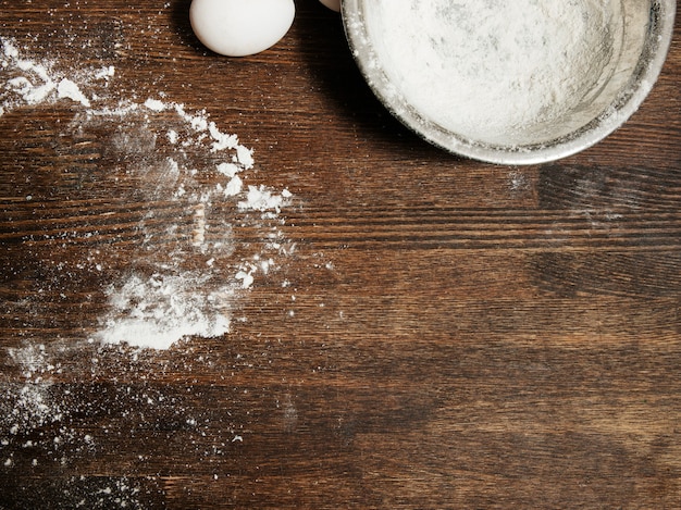 Photo dirty cooking table with flour and bowl, eggs food concept, top view copy space