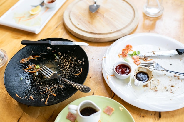 写真 食べた後の汚れた皿と木製の皿