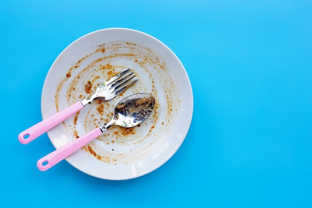 Photo dirty dish on blue background. top view