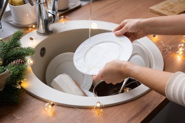 Dirty dishes in the sink in the garlanded kitchen a holiday after a feast at Christmas Mess after the guests for the New Year kitchen cleaning detergent cleaning services