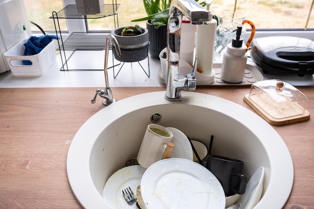 Dirty dishes in the sink in the kitchen mess after lunch too\
lazy to wash dishes kitchen cleaning detergent cleaning\
services