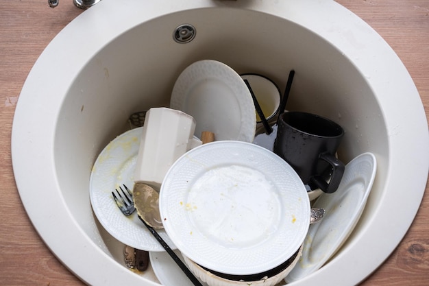 Dirty dishes in the sink in the kitchen mess after lunch too\
lazy to wash dishes kitchen cleaning detergent cleaning\
services