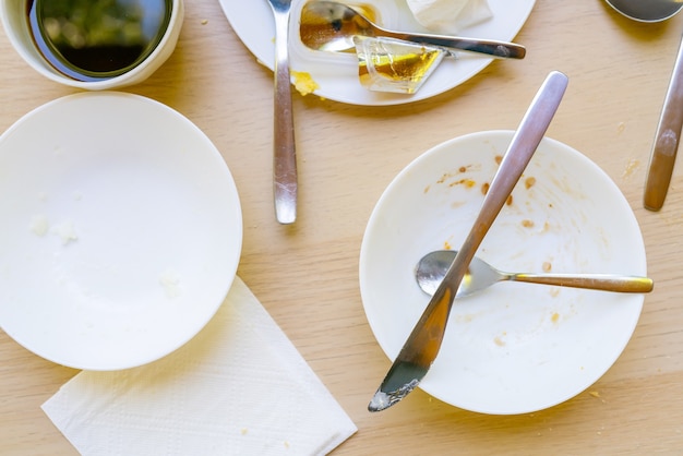 Photo dirty dishes on the table. household waste is harmful to the environment.