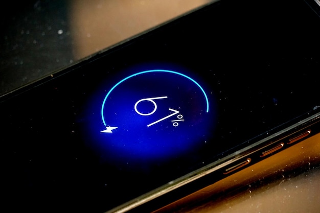 грязный дисплей смартфона с изображением на экране, показывающим уровень заряда батареи
