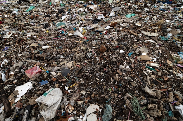 Dirty ground and filled with debris caused by the dumping from factories or industries and houses.