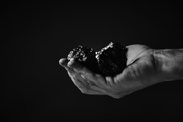 Dirty hands miner holding coal in black and white photoheavy\
coal mining