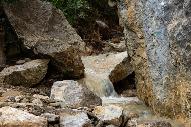 Dirty mountain river after rain, among wild rocks.