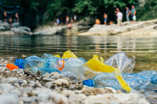 汚れたペットボトルとバッグ、水中のプラスチック