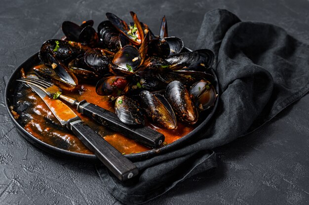 Foto piatto sporco con resti di cena, conchiglie di cozze. sfondo nero. vista dall'alto