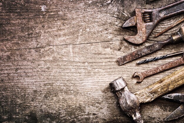 Dirty set of hand tools on a wooden background vintage photo