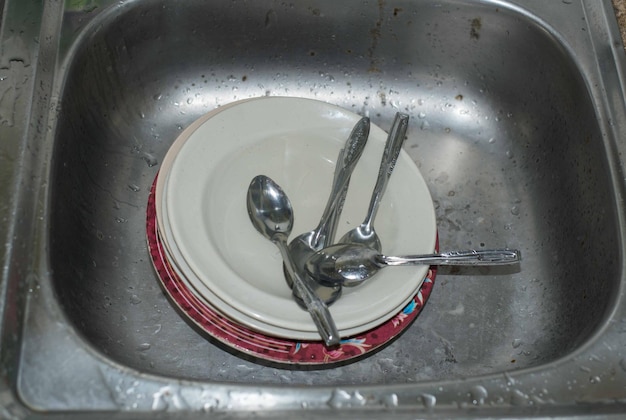 Photo dirty sink with unwashed dishes