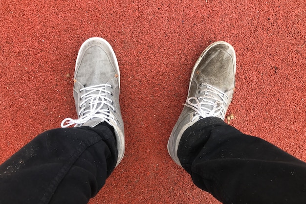 Dirty sneakers on a red background, sports shoes