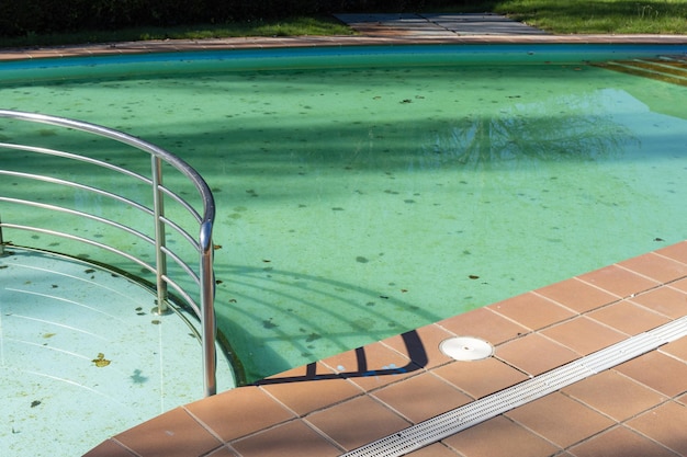 Dirty swimming pool with leaves in the pool bottom cleaning concept